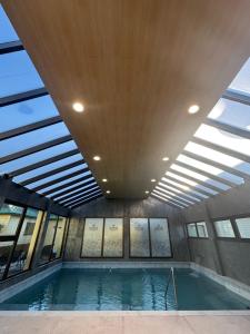 an indoor swimming pool with a ceiling with windows at Konke Calafate Hotel in El Calafate