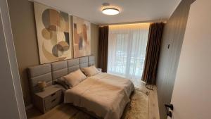 a small bedroom with a bed and a window at Apartmán beige Bardejovské Kúpele in Bardejov