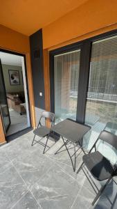 a patio with a table and chairs on a balcony at Apartmán beige Bardejovské Kúpele in Bardejov