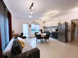 a living room with a couch and a table and a kitchen at AmurResidence 64 Sauna Parking Barbeque in Iaşi