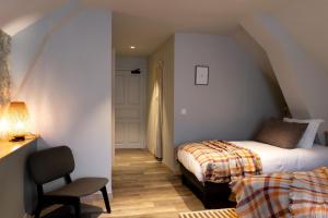 a bedroom with a bed and a chair in a room at Hotel Linette in Aumont-Aubrac