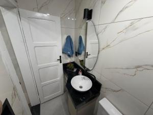 a bathroom with a white door and a sink at Casa aconchegante em Olaria in Nova Friburgo +3 photos