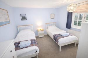 zwei Betten in einem Zimmer mit blauen Wänden in der Unterkunft Brookside, Hawkshead with garden and parking in popular village in Hawkshead