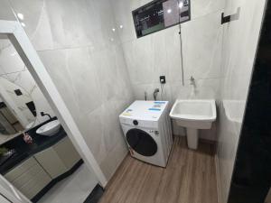 a small bathroom with a washing machine and a sink at Casa aconchegante em Olaria in Nova Friburgo