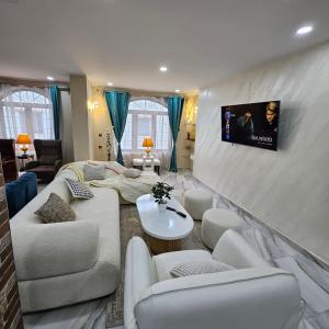 a living room with white furniture and a flat screen tv at Penthouse in Le Hamiz