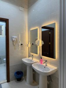 a bathroom with two sinks and a mirror at أستديو كلاود السحاب in Al Baha