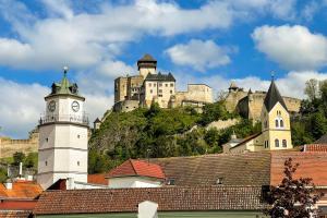 a castle on top of a hill with a clock tower at Apartmán Vita Smart in Trenčín