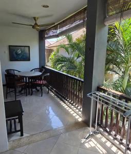 a porch with a table and chairs on a balcony at Green Cocoon at Bali beach in Sanur