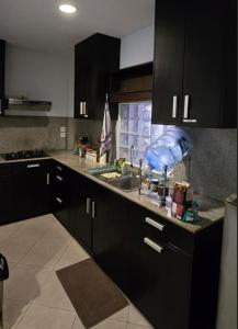 a kitchen with black cabinets and a sink at Green Cocoon at Bali beach in Sanur