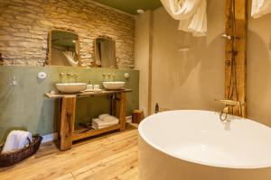 a bathroom with two sinks and a bath tub at La Chaumée par L'émulsion in Saint-Alban-de-Roche +27 photos