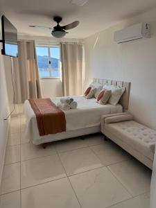 a white bedroom with a bed and a window at Mirante Piratininga - Casa 2 quartos - Vista Panorâmica Lagoa e Praia in Niterói