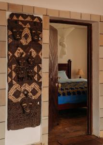a room with a bed and a wall with a quilt at Rwanda African Art Museum in Nyabisindu