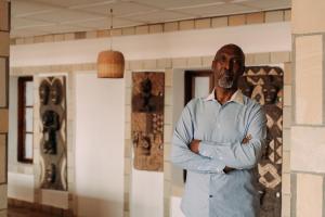 a man standing in a room with his arms crossed at Rwanda African Art Museum in Nyabisindu +5 photos