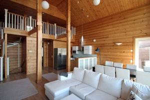 a living room with a white couch and wooden walls at Päijänteen Helmi 2 in Jämsä