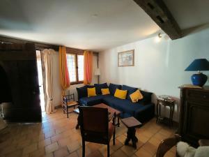 a living room with a blue couch and yellow pillows at La Toscane Médiévale in Saramon