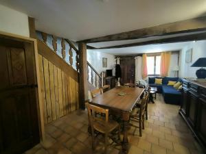 a living room with a wooden table and a blue couch at La Toscane Médiévale in Saramon