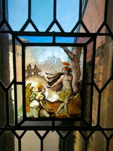 a stained glass window with a painting of two men at La Toscane Médiévale in Saramon