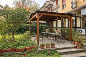 a pavilion with tables and chairs in a garden at Hotel Adler in Milan
