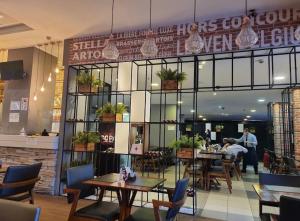 a restaurant with tables and chairs and people in the background at Flat próximo ao Aeroporto Congonhas Piscina, Academia e Restaurante in São Paulo