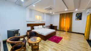 a room with a bed and a table and chairs at Reine Hôtel in Bohicon
