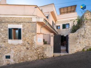 a stone house with a gate and a stone wall at La Caseta de Lola in El Port de la Selva