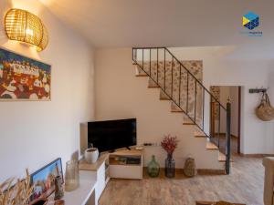 a living room with a staircase and a television at La Caseta de Lola in El Port de la Selva