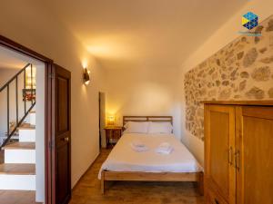 a bedroom with a bed and a stone wall at La Caseta de Lola in El Port de la Selva