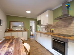 a kitchen with a wooden table and a dining room at La Caseta de Lola in El Port de la Selva