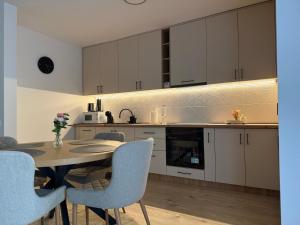 a kitchen with white cabinets and a table and chairs at IDDA Concept 3 in Târgu-Mureş