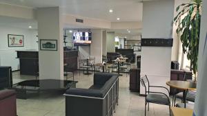 a restaurant with tables and chairs and a bar at Apart Hotel Alvear in Rosario