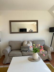 a living room with a couch and a mirror at Fewo Schröder - BUDE 63a - mit Strandkorb am Meer - inklusive Bettwäsche und Handtücher in Westerdeichstrich