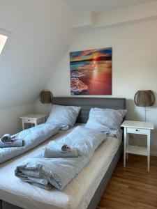 a bedroom with two beds and a painting on the wall at Fewo Schröder - BUDE 63a - mit Strandkorb am Meer - inklusive Bettwäsche und Handtücher in Westerdeichstrich