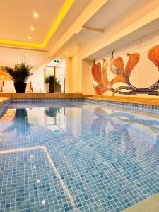 a swimming pool in a hotel with a painting on the wall at ArdoVel Park Hotel in Velingrad