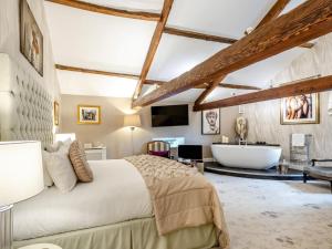 a bedroom with a large bed and a bath tub at 4 Bed in Leyburn oc-83260 in Middleham