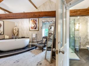 a bathroom with a large tub and a chair at 4 Bed in Leyburn oc-83260 in Middleham +38 photos
