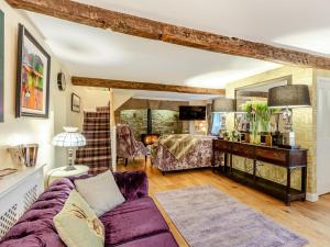 a living room with a purple couch and a table at 4 Bed in Leyburn oc-83260 in Middleham
