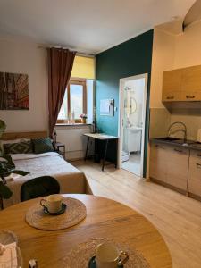 a room with a bed and a table and a kitchen at Pod Aniołami in Wałbrzych