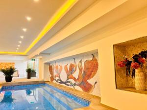 a swimming pool in a house with a painting on the wall at ArdoVel Park Hotel in Velingrad