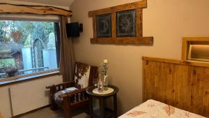a bedroom with a bed and a chair and a window at Srub u Krále in Dobruška