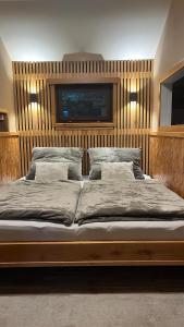 a bedroom with a large bed with two pillows at Srub u Krále in Dobruška