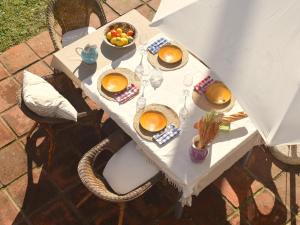 a white table with bowls of fruit on it at El Jardí de Tamariu in Tamariu