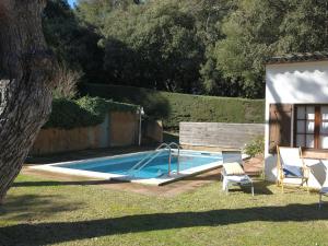 a swimming pool with two chairs and a swing at El Jardí de Tamariu in Tamariu