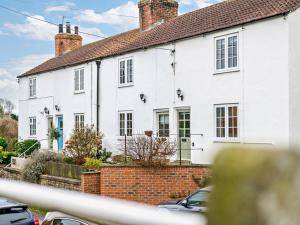 a white house with a red brick at 2 Bed in York oc-90906 in Sheriff Hutton