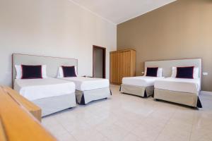 a room with three beds with pillows on them at Hotel Santa Marta in Pozzuoli
