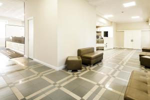 a waiting room with couches and chairs on a tile floor at Hotel Santa Marta in Pozzuoli