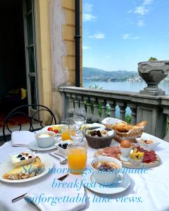 a breakfast table with food and a view of the water at B&B Villa Costanza in Blevio