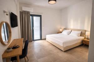 a bedroom with a bed and a desk and a mirror at CONSTA Luxury Apartments in Paralio Astros