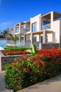 a building with red flowers in front of it at Helios Beach Hotel & Bungalows in Karpathos