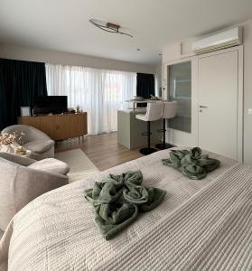a bedroom with a bed with a pile of towels on it at HelloWine Apartman II in Eger