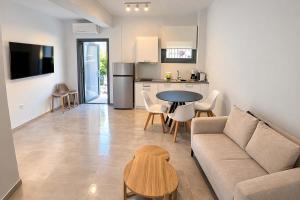a living room with a couch and a table and a kitchen at CONSTA Luxury Apartments in Paralio Astros